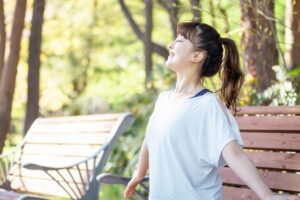 自然の中でストレッチをする若い女性