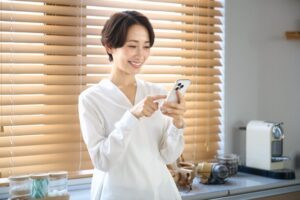 スマートフォンを見る女性　キッチン　室内