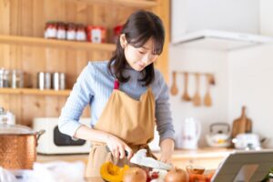 キッチンで料理をする女性（野菜を切る）