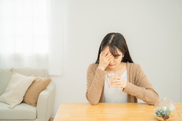 箕面市の整体 みゅう整骨院 | 【整骨院でめまいは治る？】朝のふらつきが改善した理由とはめまいによる頭痛でうつむく女性