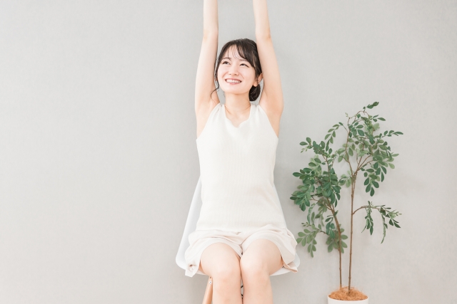 家で椅子でストレッチ・深呼吸する女性