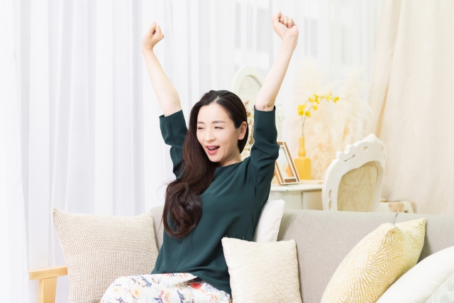 リビングのソファで深呼吸している女性