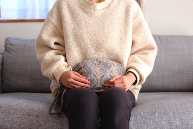 湯たんぽで体を温める女性