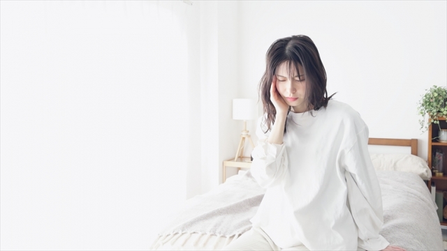 痛む顎を押さえる女性