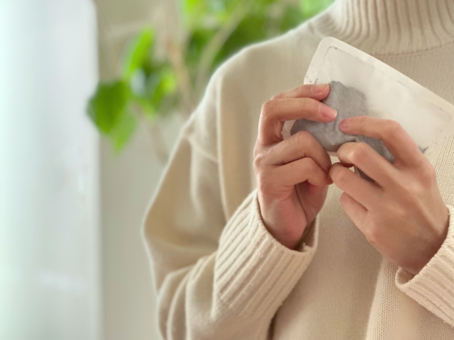 使い捨てカイロを持つ女性