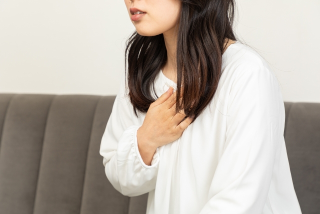 胸部の痛みや吐き気を感じる女性
