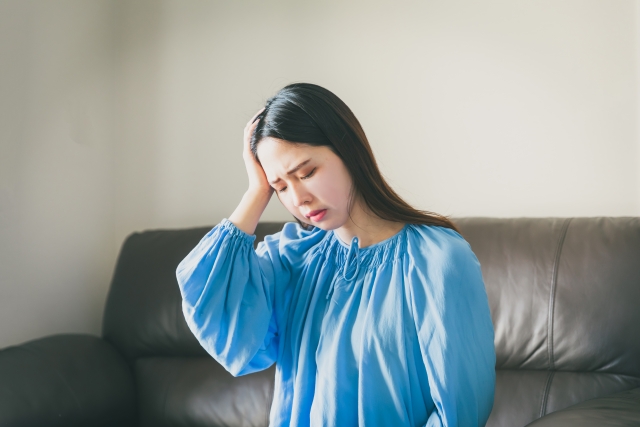 頭痛で眩暈がする女性