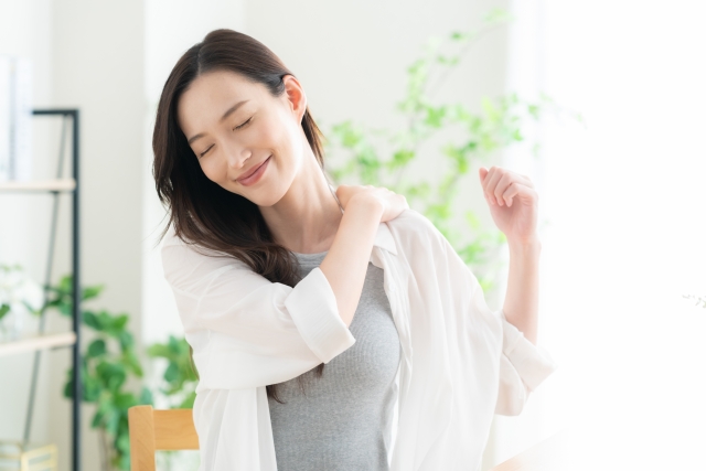 リビングでストレッチをする若い女性