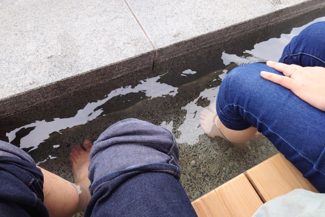 夫婦で足湯で疲れを癒すイメージ