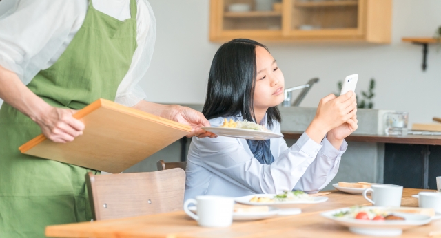 スマホを無気力にいじる女子高生