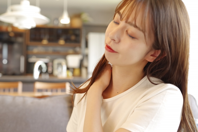 肩こりや首こりが辛そうな女性