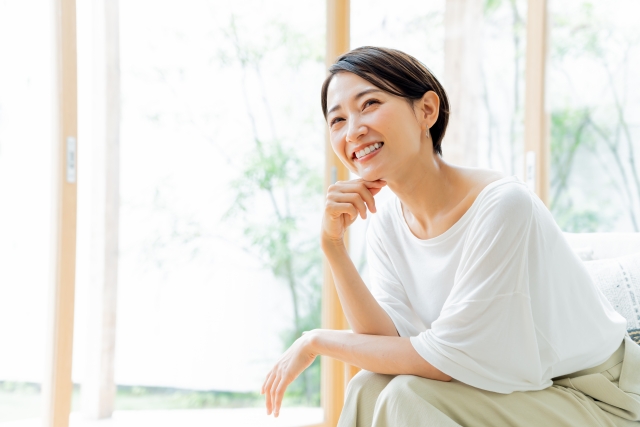 リビングのソファに座り悩む女性