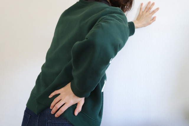 腰の痛みを感じる女性