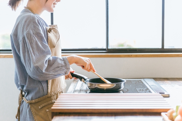 キッチンにいるエプロン姿の女性
