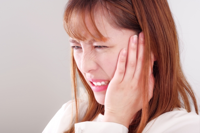 あごが痛そうな若い女性