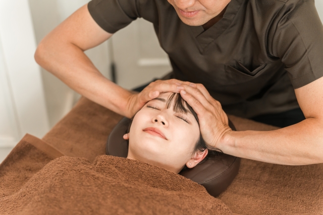 ヘッドマッサージ・小顔矯正をする女性