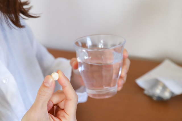 薬を飲む女性の手元