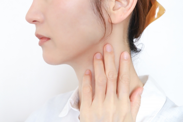 首のしこりや腫れを気にする女性